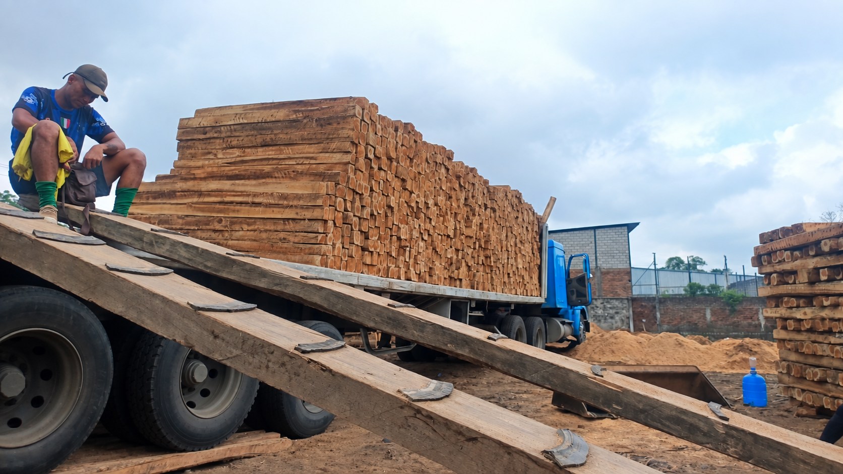 Camión cargado de piezas de madera y una rampa de acceso en el acopio.